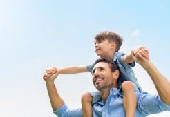 Son sitting on fathers shoulders